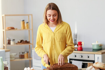 Sticker - Young woman cutting fresh bread at table in kitchen