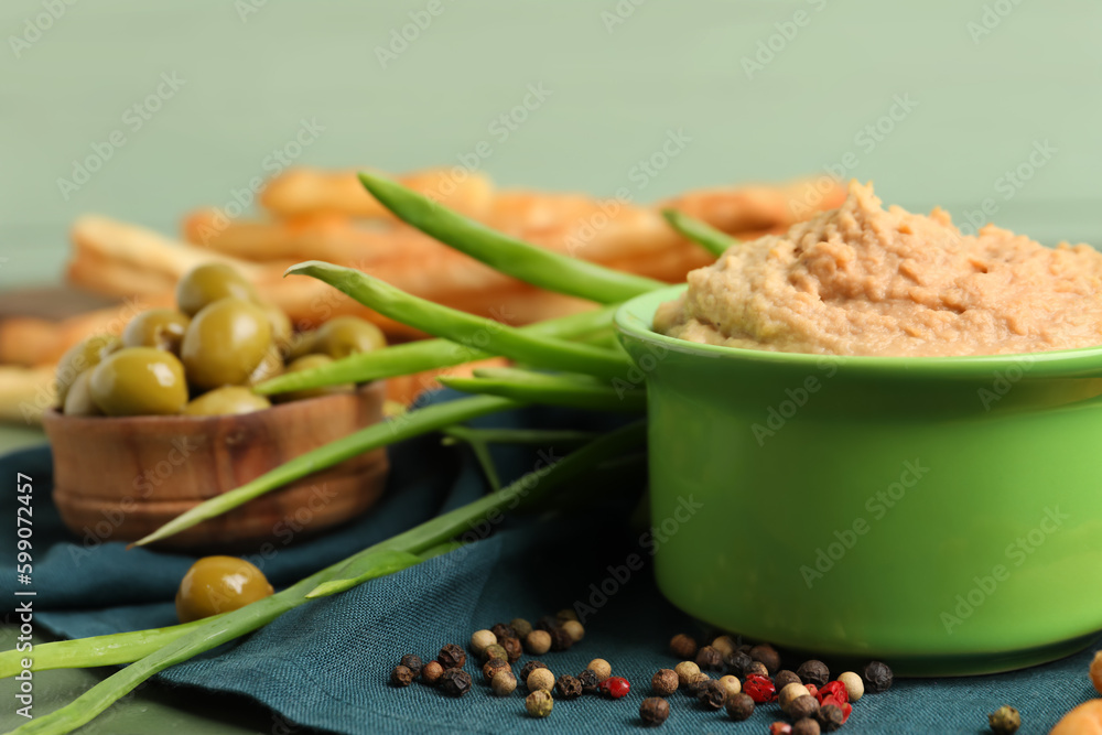 Bowl with tasty hummus on table, closeup