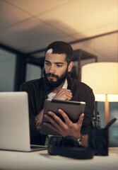 Sticker - Beat any deadline with a boss mindset. a young businessman using a digital tablet and laptop during a late night at work.