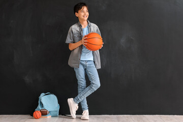 Wall Mural - Little boy with ball near blackboard. Children's Day celebration