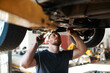 © J Bergen/peopleimages.com - Heres where the problem lies. a mechanic working under a lifted car.