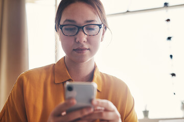 Aufkleber - Checking my social media. an attractive young businesswoman sitting alone in her home office and texting on her cellphone.