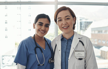 Sticker - At your service. two young health workers in a hospital.