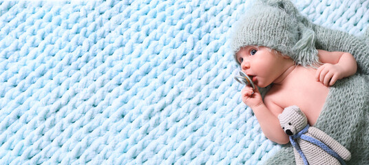 cute baby baby with pacifier and crochet toy on light blue blanket, top view. banner design with spa