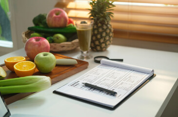 sheet of diet plan and different healthy food ingredients on white table. dieting, healthy lifestyle