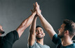 © Courtney H/peopleimages.com - Lets do this. a group of handsome young male athletes high fiving against a grey background.