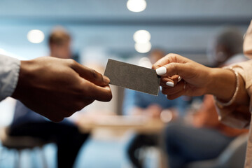 Youll need this one of these days. two businesspeople exchanging business cards at a conference.