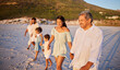 © Alexis Scholtz/peopleimages.com - Multi generation family holding hands and walking along the beach together. Mixed race family with two children, two parents and grandparents enjoying summer vacation