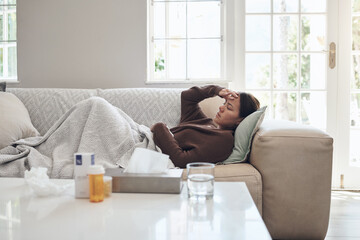 Sticker - My temperature hasnt gone down. a young woman lying on a sofa while feeling sick at home.