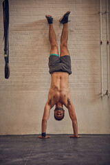 Wall Mural - I do this for the strength. Full length portrait of a handsome young man doing handstands while working out in the gym.