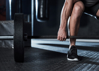 Wall Mural - To get stronger, get lifting. an unrecognisable man lifting a barbell during his workout at a gym.