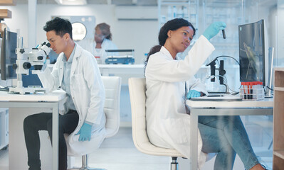 Wall Mural - concentration is at its peak. a young lab technician analysing a test tube sample.