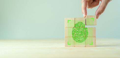 Wall Mural - Fingerprint scanning identification system. Biometric authorization and personal security. Green fingerprint with green transparency light on wooden cube blocks on clear background and copy space.