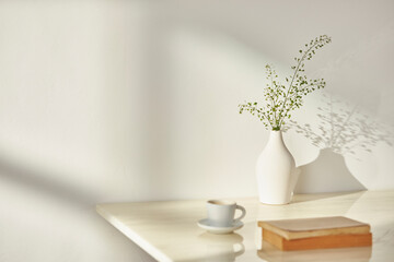 Vases and objects on the table in a warm room with sunlight coming in