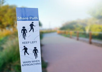 Safety shared signs on footpath for cycling and walking on blurred background.	