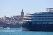 Cruise ship in the city port in the city port for tourist travel on a sunny day. The historic galata tower, which is the symbol of the city of Istanbul, is in the background.