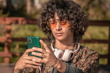 Wall Mural - young hippie man with mobile phone and headphones