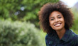 © Mapodile M/peopleimages.com - Black woman outdoor in portrait, smile in nature with positive mindset with mockup space. Headshot of happy female person, young and carefree with curly afro hairstyle and happiness at the park