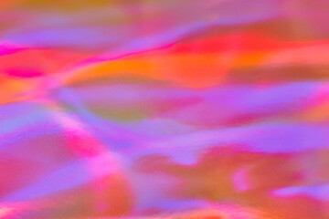 Blurred ethereal pastel neon pink, purple, blue, orange holographic metallic foil background texture. Abstract rainbow disco, rave, festive backdrop, Lo-fi multicolor optimistic vintage retro design