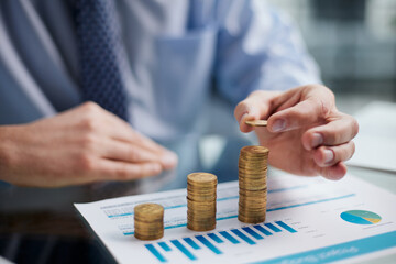 Wall Mural - Businessman stacking coins on table, business growth concept. Hand puts coin to stack.