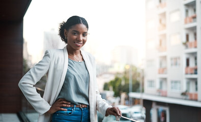 Poster - My companys about to take over the city. Portrait of a confident young businesswoman standing outside on the balcony of a modern office.