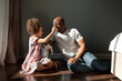 © Anna Zhuk - Happy African American father and his daughter playing with plush toy together. Child girl having fun with dad, sitting on floor at home, smiling. Authentic portrait on sunny day