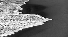 Black Sandy Beach With Splashing Water, Surf, Bubbles, Wave Foam And Low Evening Sunlight. Black And White Greyscale. “Anse Couleuvre“ Is A Remote Secluded Beach On Tropical Island Martinique. 