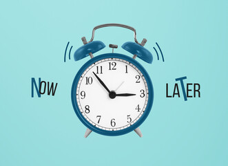 Creative top view flat lay of alarm clock with words about doing tasks now or later on blue background . Concept of time management in business and life