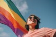 © Wizzi - Asian queer person holding rainbow flag LGBT pride or gay pride. Lesbian, gay, bisexual, and transgender (LGBT) people proud of their sexual orientation and gender identity. Created with generative AI