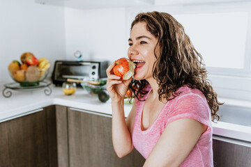 Wall Mural - Latin adult woman healthy eating in the kitchen at home in Mexico, Hispanic female wellbeing	in Latin America