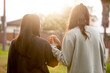 © Austockphoto - Two Aboriginal young women walking together holding hands