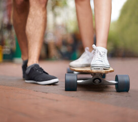 Wall Mural - Just he skateboard essentials. Waist down shot of two people standing with a skateboard.