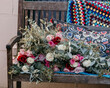 © Austockphoto - Crochet blanket and fresh flowers on a garden seat.