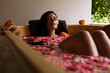 canvas print picture - Attractive woman in bathtub with flowers