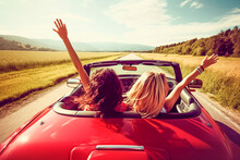 Two Girls In A Red Car With Their Hands Up Driving Through A Valley In Summer