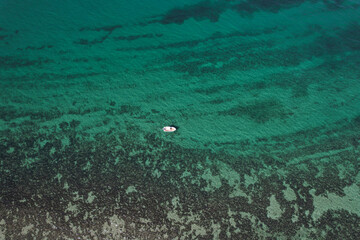 Wall Mural - One small white boat cruising along the reef in Exmouth, Western Australia. Beautiful turquoise water and corals view from the sky. 