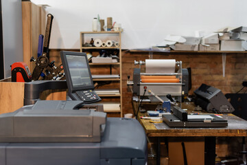 modern print center equipment next to monitor and paper trimmer.