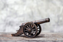 Ancient Cannon On Steel Wheels With Wall Background Retro Style.