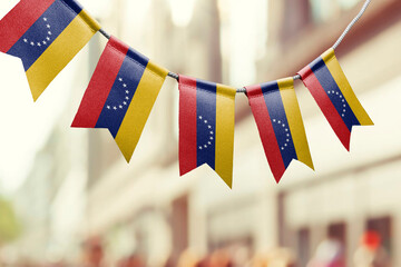 A garland of Venezuela national flags on an abstract blurred background