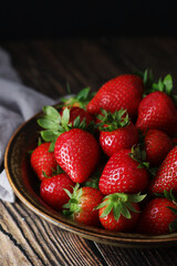 Wall Mural - A bowl with ripe bright strawberry in rustic style	