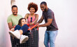 ©  Yistocking - A group of 3 multiracial millennial youths have a good time pushing a girl inside a shopping cart outside the street. Concept of fun among young people, carefree, end of exams, university parties.