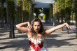 © @skuder_photographer - Latin woman, young and beautiful dancing modern dance in the street in a park and makes different expressions and postures. Concept dance, hip hop, dance, art, action, beauty, youth art.