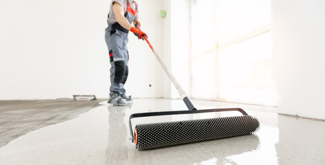 Master with needle roller for new screed concrete with self leveling cement mortar for floors. Concept building renovation home