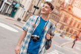 Fototapeta Londyn - Outdoor portrait of man using a camera and taking photos in the city of Europe. Enjoying travel concept