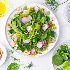 Wall Mural - Healthy diet salad for lunch with many types of cereals and legumes (barley, lentils, beans, peas), baby spinach, green leaves and herbs, seasoned with olive oil, white background, square crop