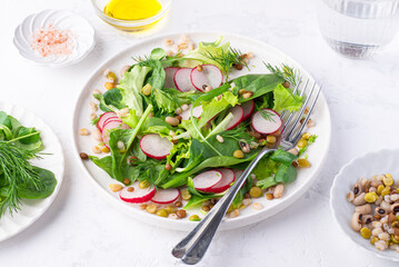 Wall Mural - Healthy diet salad for lunch with many types of cereals and legumes (barley, lentils, beans, peas), baby spinach, green leaves and herbs, seasoned with olive oil, white background, spring and summer m