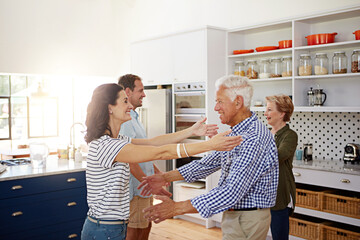 Poster - Hugs are freely given in this house. a loving family greeting each other with hugs in the kitchen at home.