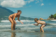 Mãe e filho brincando no mar da praia no verão