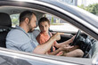 © LIGHTFIELD STUDIOS - bearded father talking to teenage son while teaching him how to drive car.