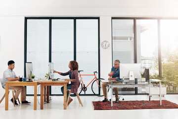 Poster - The office is in full flow. Full length shot of three designers working in their creative office environment.